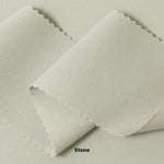 A swatch of knit pique fabric in a light beige color, showing the texture and weave of the material.