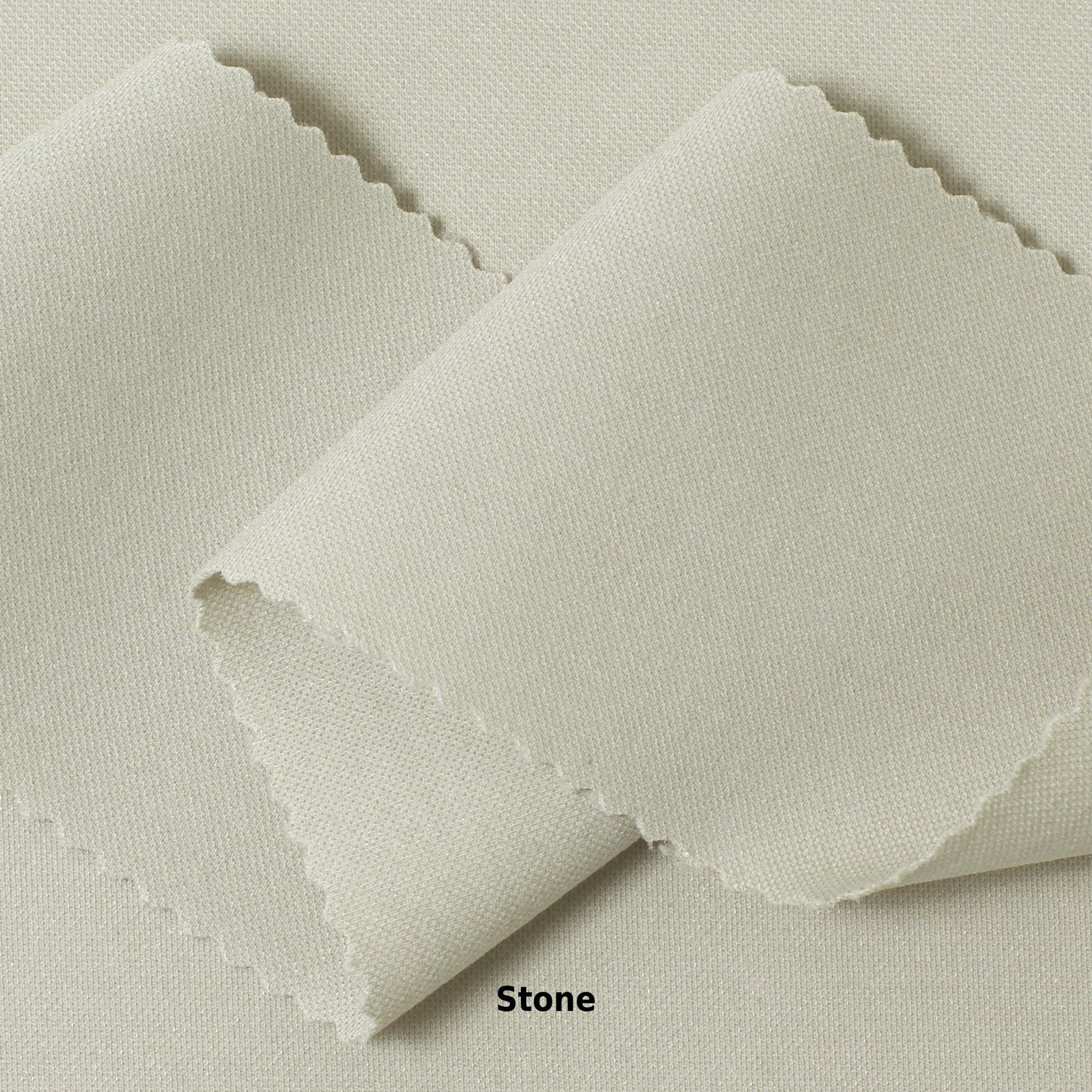 A swatch of knit pique fabric in a light beige color, showing the texture and weave of the material.